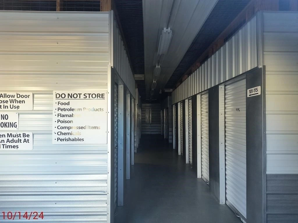 Interior view of a self-storage unit featuring various organizational signs on the walls.
